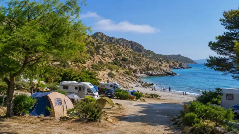 Camping à El Port de la Selva avec tentes et camping-cars face à une crique de la Costa Brava