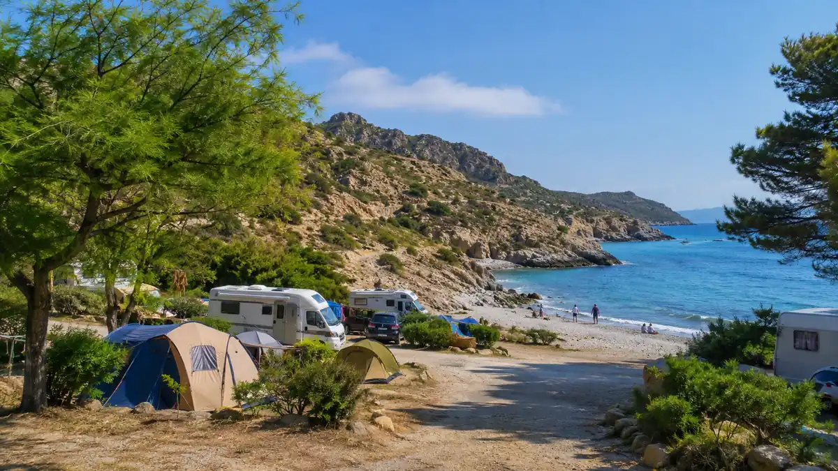 Camping à El Port de la Selva avec tentes et camping-cars face à une crique de la Costa Brava